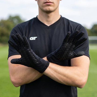 Voetballer draagt GT Field Player Gloves met grip op de handpalm