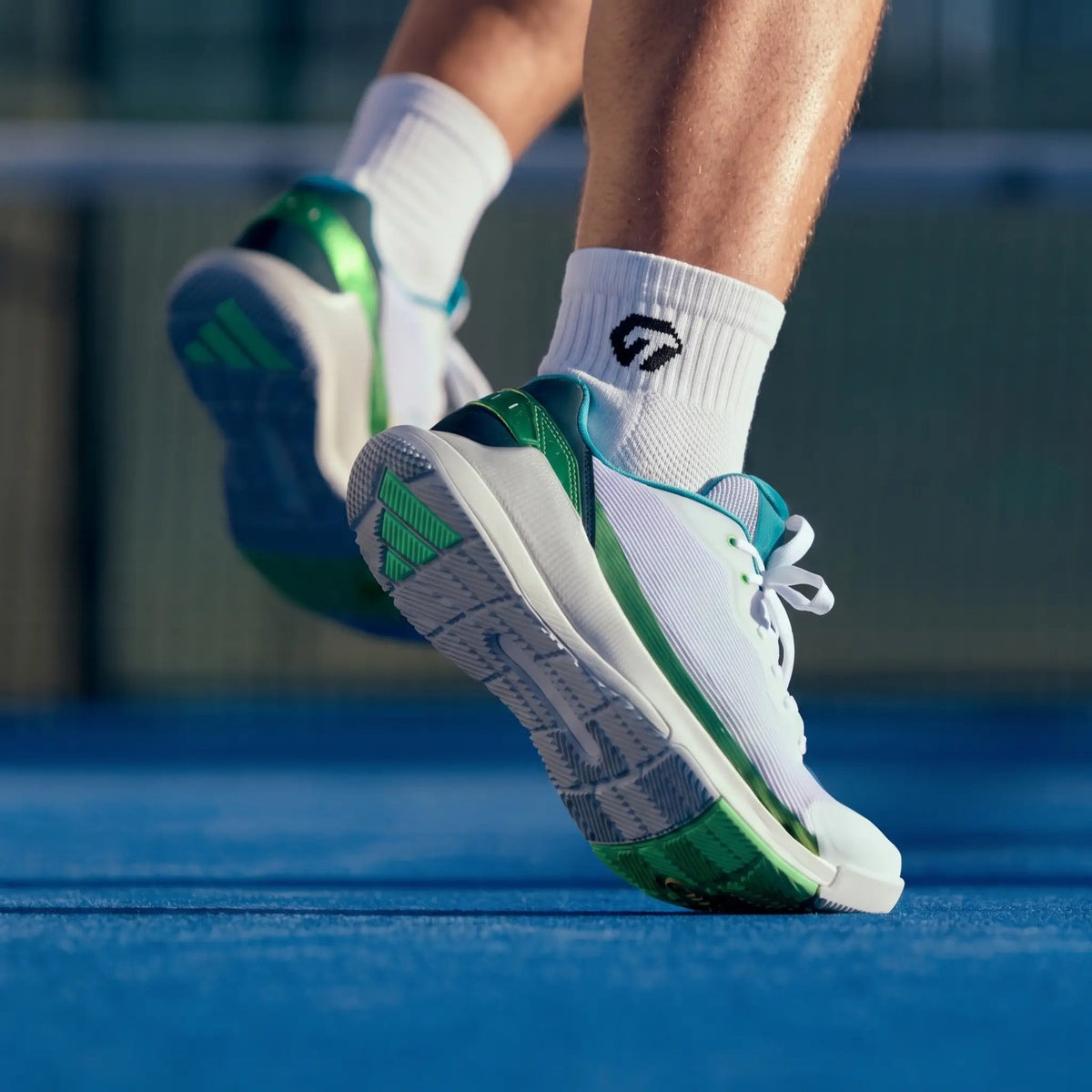 Padelspeler met witte GT Ankle Grip Socks in padelschoenen op een blauwe padelbaan | GT Sport Selection